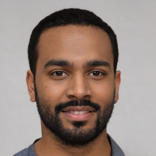 Joyful black young-adult male with short  black hair and brown eyes