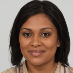 Joyful black adult female with medium  brown hair and brown eyes