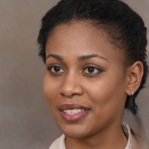 Joyful black young-adult female with short  brown hair and brown eyes