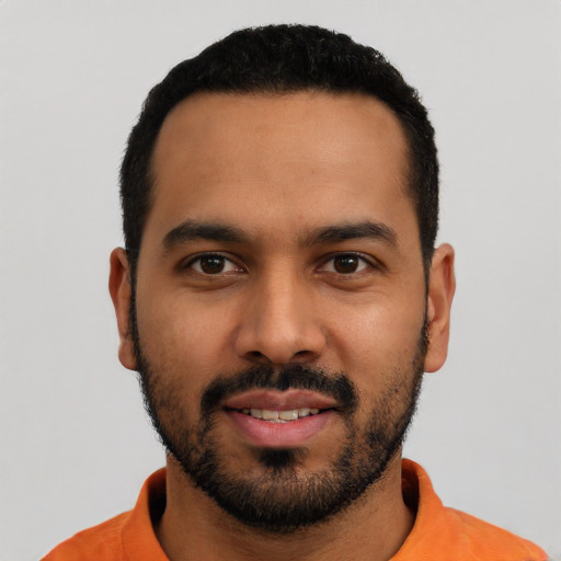 Joyful latino young-adult male with short  black hair and brown eyes