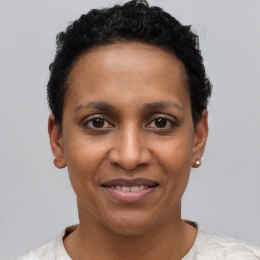Joyful black young-adult female with short  black hair and brown eyes