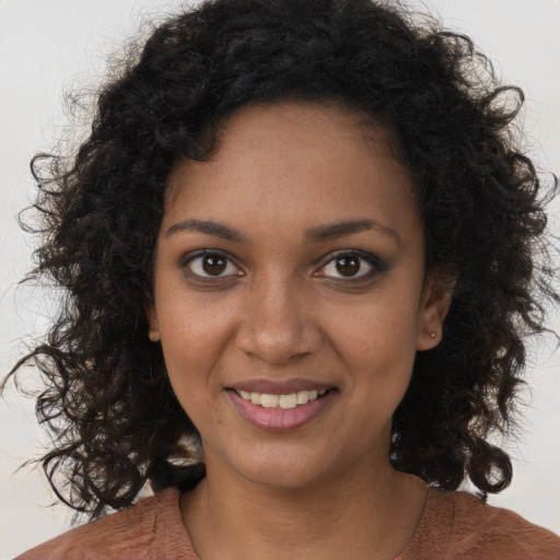 Joyful black young-adult female with long  brown hair and brown eyes