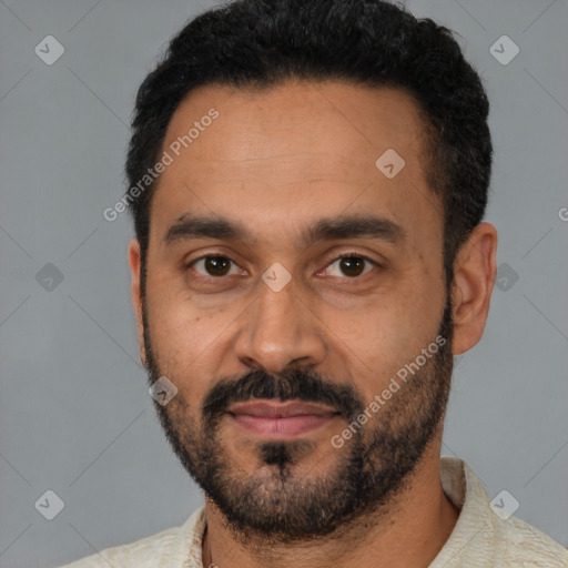 Joyful latino adult male with short  black hair and brown eyes