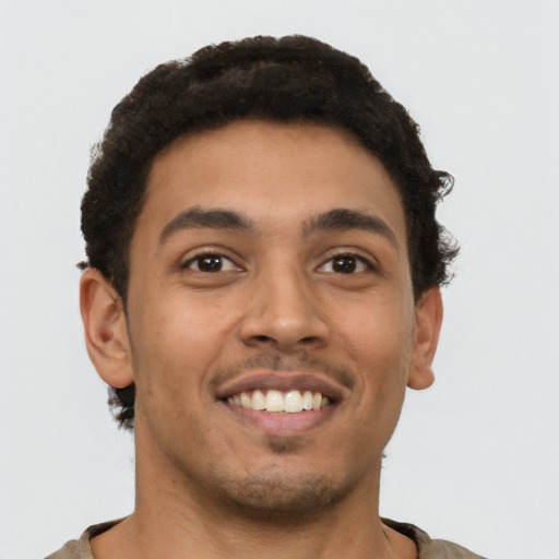 Joyful latino young-adult male with short  brown hair and brown eyes