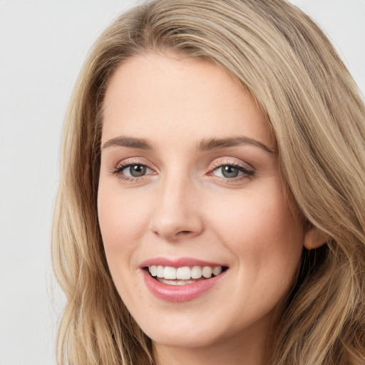 Joyful white young-adult female with long  brown hair and blue eyes