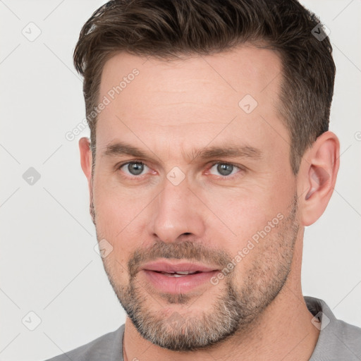 Joyful white adult male with short  brown hair and brown eyes