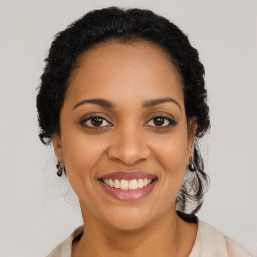 Joyful black young-adult female with long  black hair and brown eyes