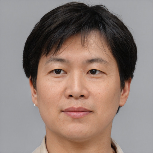 Joyful asian adult male with short  brown hair and brown eyes