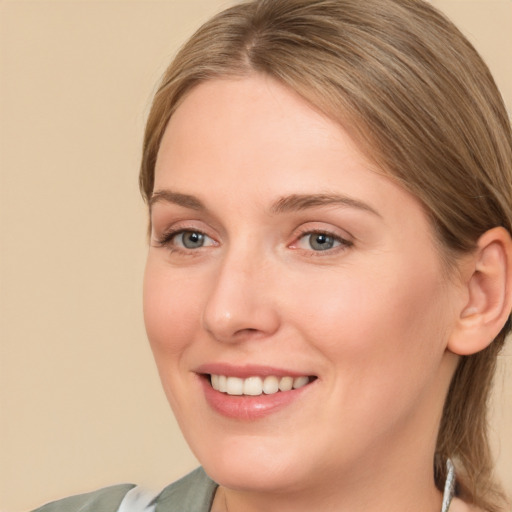 Joyful white young-adult female with medium  brown hair and grey eyes