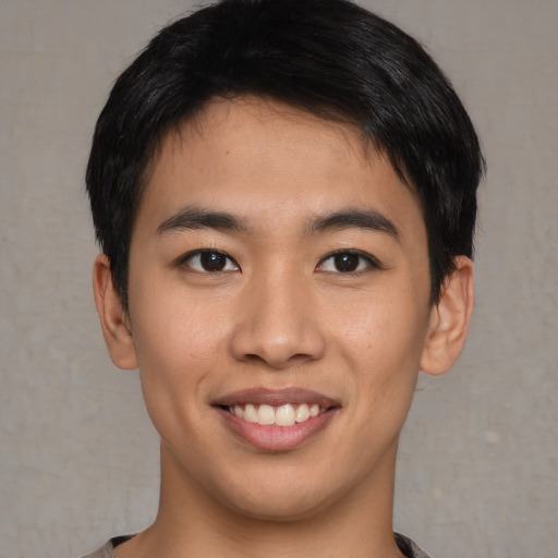 Joyful asian young-adult male with short  brown hair and brown eyes