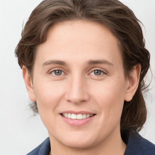 Joyful white young-adult female with medium  brown hair and grey eyes