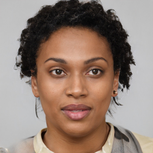 Joyful black young-adult female with short  brown hair and brown eyes