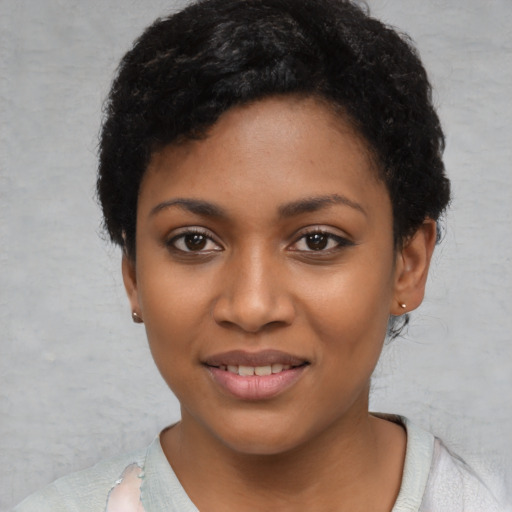 Joyful black young-adult female with short  black hair and brown eyes