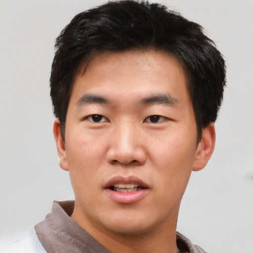 Joyful asian young-adult male with short  black hair and brown eyes