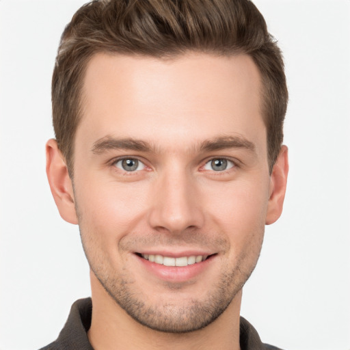 Joyful white young-adult male with short  brown hair and grey eyes