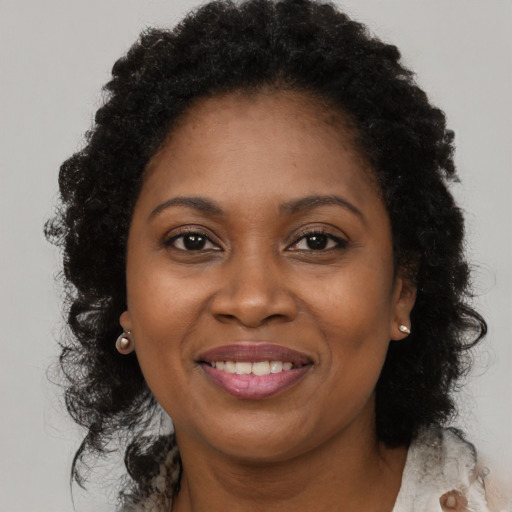 Joyful black young-adult female with long  brown hair and brown eyes