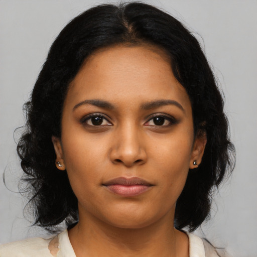 Joyful black young-adult female with long  black hair and brown eyes