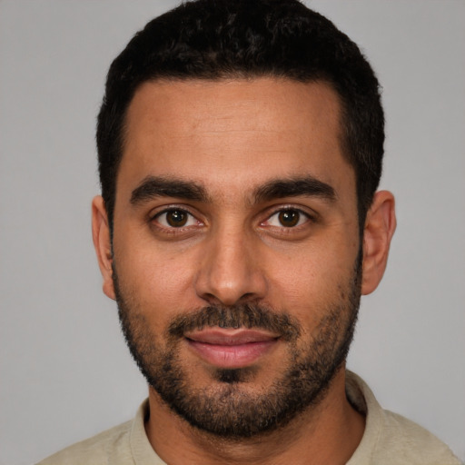 Joyful latino young-adult male with short  black hair and brown eyes