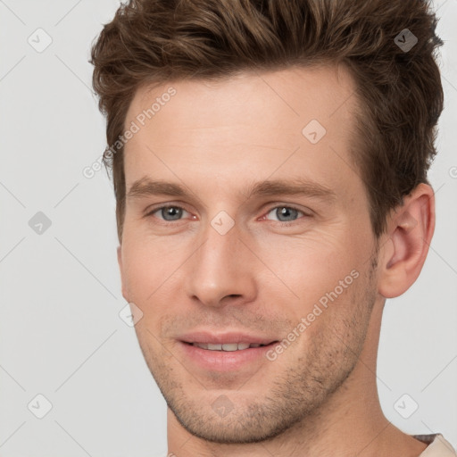 Joyful white young-adult male with short  brown hair and grey eyes