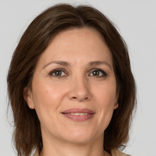 Joyful white adult female with medium  brown hair and grey eyes