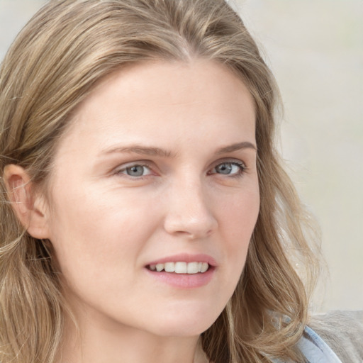 Joyful white young-adult female with long  brown hair and blue eyes