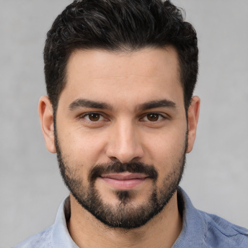 Joyful white young-adult male with short  black hair and brown eyes