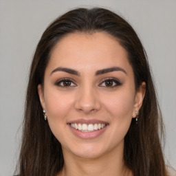 Joyful white young-adult female with long  brown hair and brown eyes