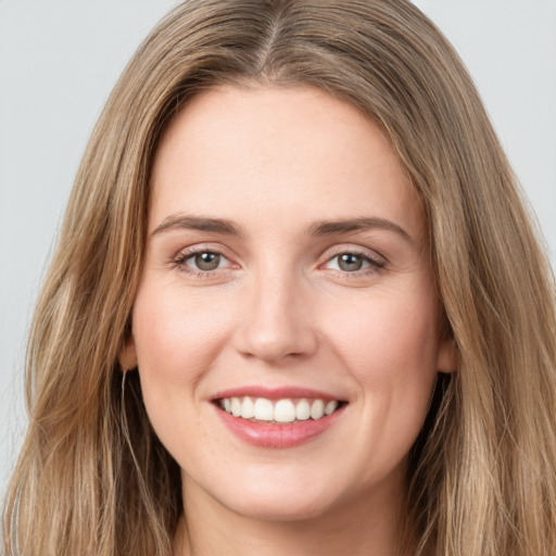 Joyful white young-adult female with long  brown hair and green eyes