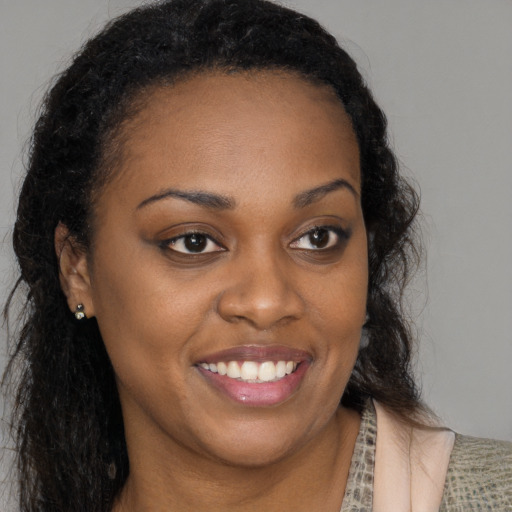 Joyful black young-adult female with long  brown hair and brown eyes