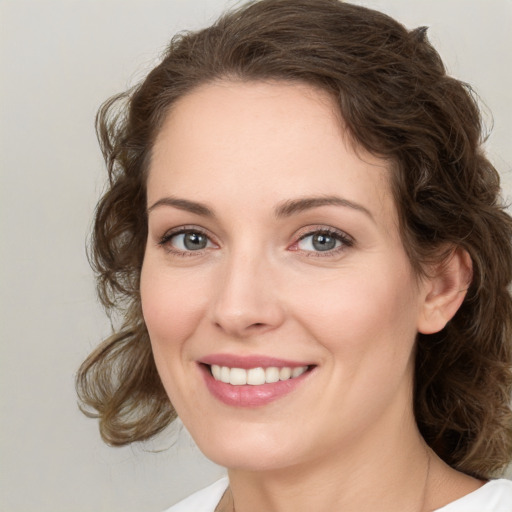 Joyful white young-adult female with medium  brown hair and green eyes