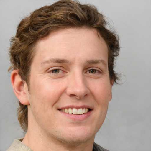 Joyful white adult male with short  brown hair and blue eyes