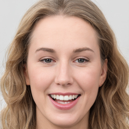 Joyful white young-adult female with long  brown hair and grey eyes