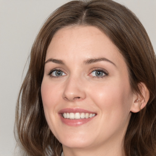 Joyful white young-adult female with medium  brown hair and grey eyes