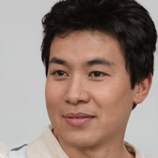 Joyful asian adult male with short  brown hair and brown eyes