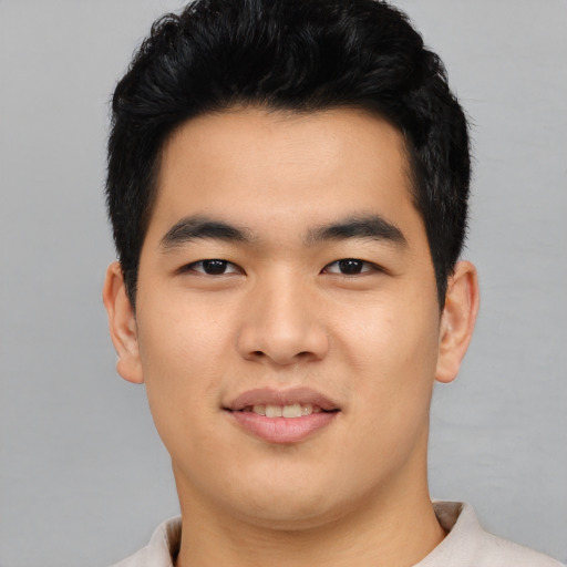 Joyful asian young-adult male with short  black hair and brown eyes