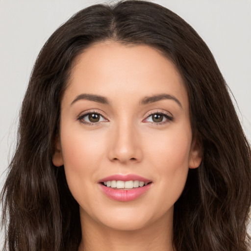 Joyful white young-adult female with long  brown hair and brown eyes