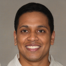 Joyful latino young-adult male with short  black hair and brown eyes