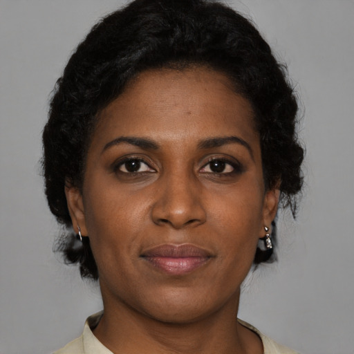 Joyful black young-adult female with short  brown hair and brown eyes