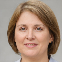 Joyful white adult female with medium  brown hair and blue eyes