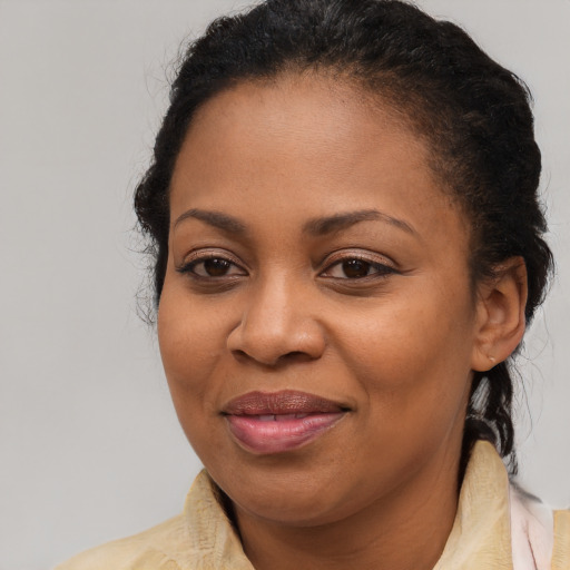 Joyful black young-adult female with long  brown hair and brown eyes