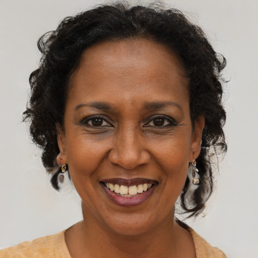 Joyful black adult female with medium  brown hair and brown eyes