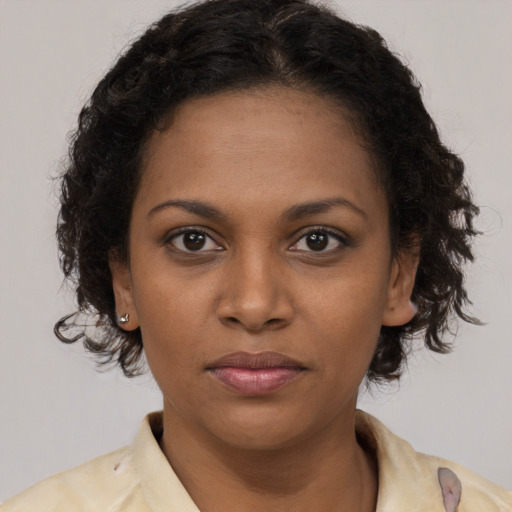 Joyful black young-adult female with long  brown hair and brown eyes
