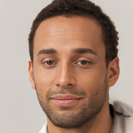 Joyful black young-adult male with short  brown hair and brown eyes