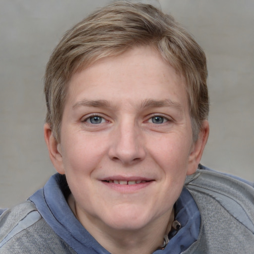 Joyful white young-adult female with short  brown hair and blue eyes