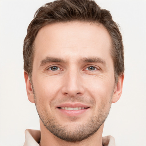 Joyful white young-adult male with short  brown hair and grey eyes