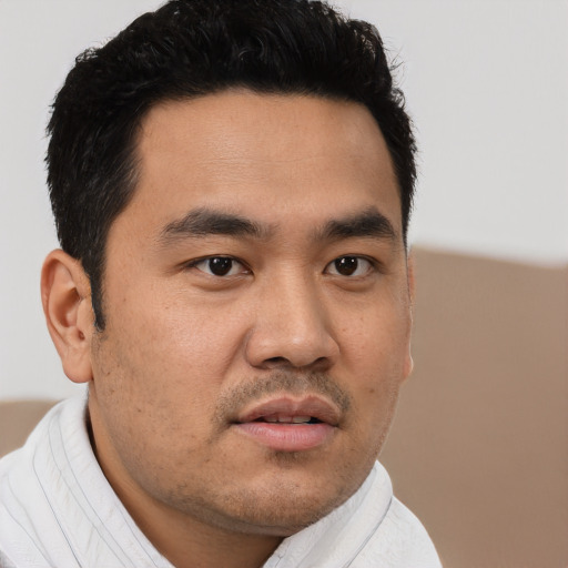 Joyful asian young-adult male with short  black hair and brown eyes