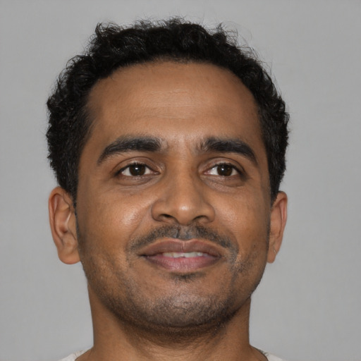 Joyful black young-adult male with short  brown hair and brown eyes