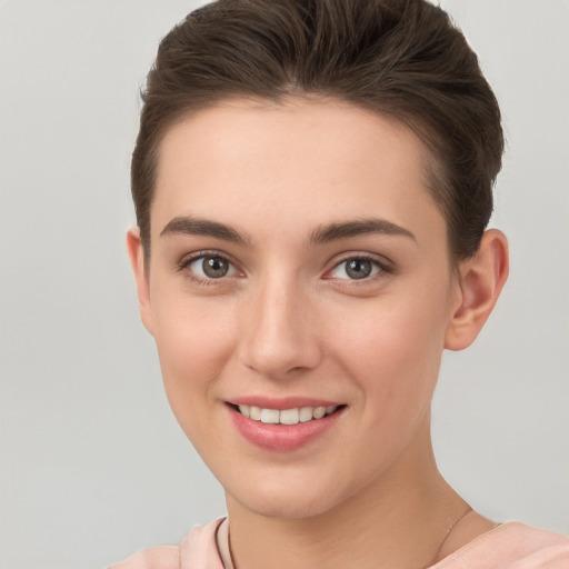 Joyful white young-adult female with short  brown hair and brown eyes