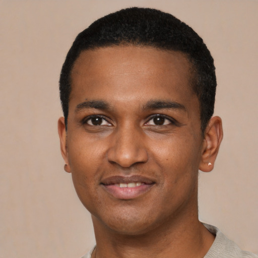 Joyful black young-adult male with short  black hair and brown eyes