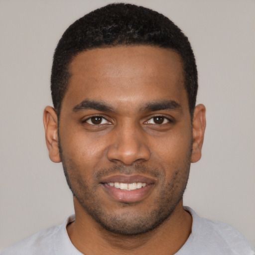 Joyful black young-adult male with short  black hair and brown eyes